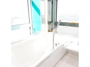 a white bathroom with a tub and a sink at Sakishima Cosmo Tower Hotel - Vacation STAY 01082v in Osaka