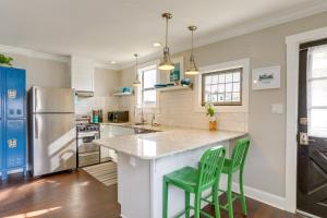 a kitchen with a counter and two green stools at Bright St Petersburg Apartment, Walk to Downtown! in St Petersburg