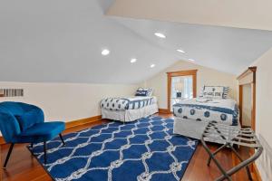 een slaapkamer met 2 bedden en een blauwe stoel bij Flagler Cottage - 1 Block to Historic District in St. Augustine