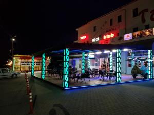 a building with blue and green lights on a street at TALIJA in Mrčajevci