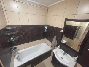 a bathroom with a bath tub and a sink at Apartman Zenica in Zenica