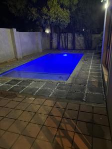 a swimming pool at night with blue water at Cheerful 3-bedroom home with backup power around Sandton in Sandton