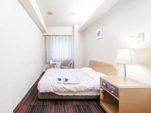 a small room with a bed and a table and a lamp at Hotel Tetora Spirit Sapporo - Vacation STAY 59354v in Sapporo