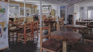 um restaurante com mesas e cadeiras de madeira numa sala em Incognito Reggae Rooms em Kingston