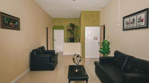 金斯敦的住宿－Incognito Reggae Rooms，客厅配有两张黑色沙发和一张桌子