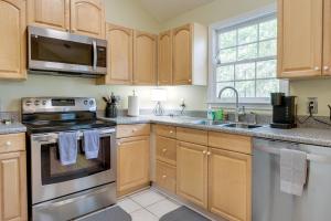 a kitchen with wooden cabinets and stainless steel appliances at Pet-Friendly LaGrange Vacation Rental with Deck! in LaGrange