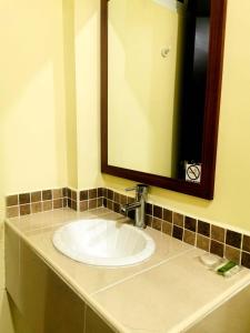 Hotel JL في Tierra Blanca: منضدة الحمام مع الحوض والمرآة