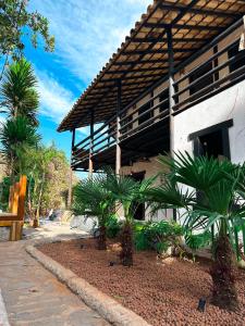 a building with palm trees in front of it at Pousada Entre Folhas in Serra do Cipo