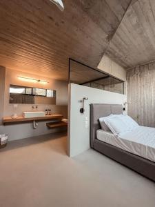 a bedroom with a large bed and a sink at Mare e Pietra -Pietra Luxury Villa Pefkali in Pefkali