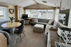 a living room with a couch and a table at 8 berth pet friendly caravan, Penrhyn Bay, Llandudno in Llandudno