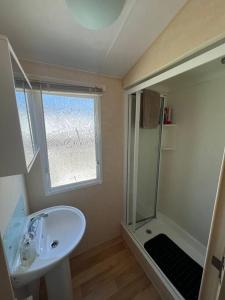 a bathroom with a sink and a shower at 8 berth pet friendly caravan, Penrhyn Bay, Llandudno in Llandudno