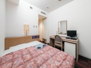 une chambre d'hôtel avec un lit et un bureau avec un ordinateur dans l'établissement Hotel Tetora Spirit Sapporo - Vacation STAY 59361v, à Sapporo