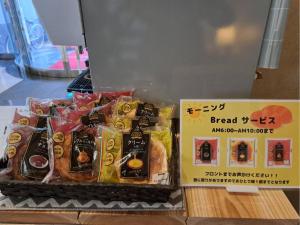 deux sacs de nourriture sur une table à côté d'un panneau dans l'établissement Hotel Tetora Spirit Sapporo - Vacation STAY 59351v, à Sapporo
