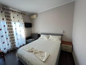 - une chambre avec un lit doté de draps blancs et une fenêtre dans l'établissement Waveside Apartment Getaway, à Durrës