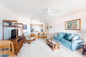 sala de estar con sofá azul y mesa en Wailua Bay View Resort en Kapaa