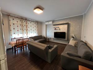 - un salon avec deux canapés et une télévision dans l'établissement Waveside Apartment Getaway, à Durrës