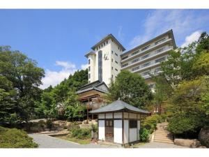 日光的住宿－Kinugawa Onsen Yusuikiko Hotel Otaki - Vacation STAY 68836v，一座白色的大建筑,前面有一座塔