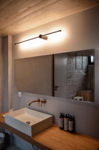 a bathroom with a sink and a large mirror at Mare e Pietra -Pietra Luxury Villa Pefkali in Pefkali