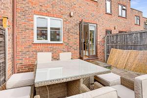 a patio with a table and chairs and a brick building at Beautiful Richmond House in Richmond upon Thames