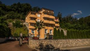 a tall yellow building with a palm tree in front of it at Apartments Villa Marta in Opatija