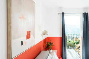 a room with an orange accent wall and a window at Beautiful Bath garden flat with stunning views - Mycityhaven in Bath