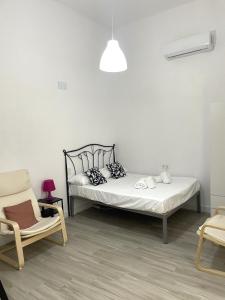 1 dormitorio blanco con 1 cama y 1 silla en Apartamento Sotos de la Axerquía 2 en Córdoba