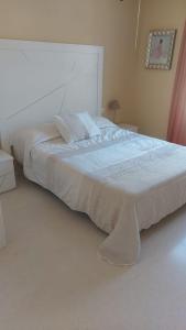 1 dormitorio con 1 cama blanca grande con almohadas en Hotel Rural-Restaurante Los Olivos en Almería