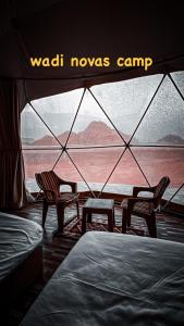 two chairs and a tent with a view of the desert at wadi novas camp in Wadi Rum
