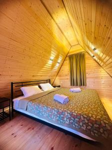 een slaapkamer met een bed in een houten kamer bij Panorama Racha in Ambrolauri