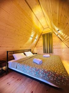 a bedroom with a bed in a wooden room at Panorama Racha in Ambrolauri