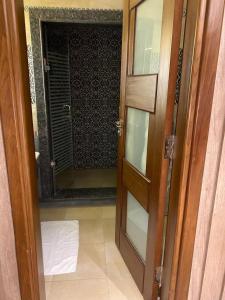 une porte menant à une salle de bains avec une porte en verre. dans l'établissement اليجريا الشيخ زايد, à Sheikh Zayed