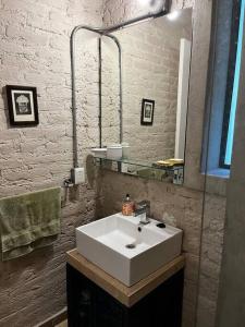 W łazience znajduje się biała umywalka i lustro. w obiekcie Departamento Arcano w mieście Meksyk
