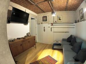 a living room with a couch and a flat screen tv at Departamento Arcano in Mexico City