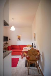 ティローロにあるVilla Ladurnerのリビングルーム(赤いソファ、テーブル付)