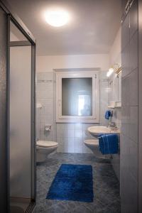 ティローロにあるVilla Ladurnerのバスルーム(洗面台2台、トイレ、鏡付)