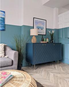 a living room with a blue wall at Beautifully decorated large family home in seaside town with large garden in Colwyn Bay