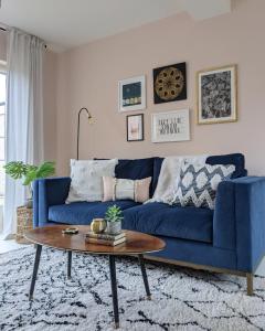 a blue couch in a living room with a table at Beautifully decorated large family home in seaside town with large garden in Colwyn Bay