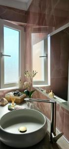 a bathroom with a sink and a large mirror at Nuçi's Place, lovely apt with balcony near Blloku in Tirana