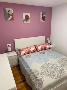 1 dormitorio con cama y pared púrpura en Os netos de Fina e Tino en Cariño