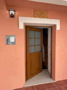 un mur orange avec une porte en bois dans une maison dans l'établissement Os netos de Fina e Tino, à Cariño