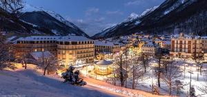 a town in the snow at night with mountains at Studio Cauterets centre - le Macadau in Cauterets