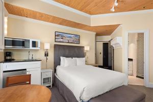 a bedroom with a bed and a desk and a table at Independence Square 305, Remodeled, 3rd Floor Hotel Room in Aspen's Best Location in Aspen