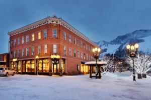 un grand bâtiment en briques rouges dans la neige dans l'établissement Independence Square 305, Remodeled, 3rd Floor Hotel Room in Aspen's Best Location, à Aspen