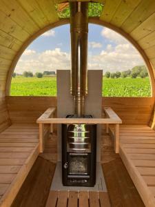 an inside view of a stove in a room with a window at Roulotte Hartemeers in Tielt