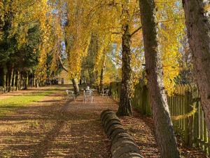 a park with a fence and tables and trees at Odpocznij in Dąbrówka +11 photos