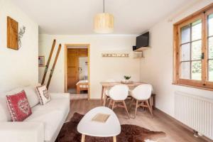 a living room with a white couch and a table at Rare, quite & centered Apartment with Garden & Fireplace in Villars-sur-Ollon