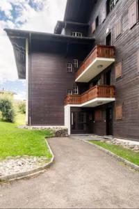 a large building with a balcony on the side of it at Rare, quite & centered Apartment with Garden & Fireplace in Villars-sur-Ollon