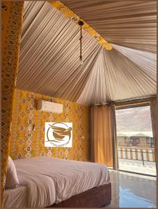 - une chambre avec un lit à baldaquin et une fenêtre dans l'établissement Victoria Desert Camp, à Disah