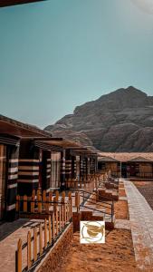 une rangée de bancs en bois devant un bâtiment dans l'établissement Victoria Desert Camp, à Disah