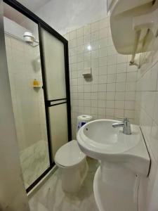 Un baño con inodoro, lavabo y ducha. en Casa Laura, en Medellín
